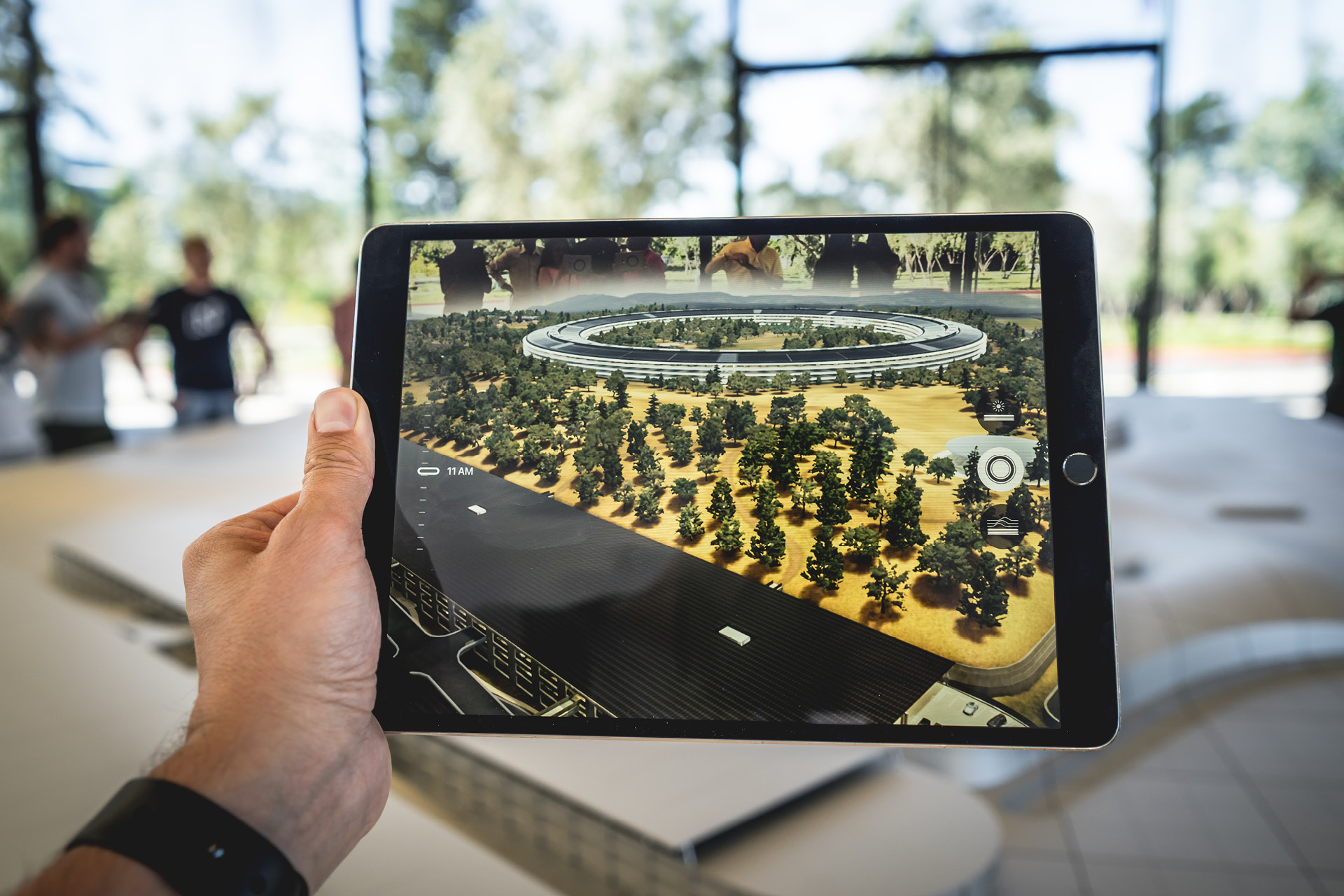 Person hält Tablet über ein Architekturmodell und sieht digitale Visualisierung der geplanten Umsetzung.