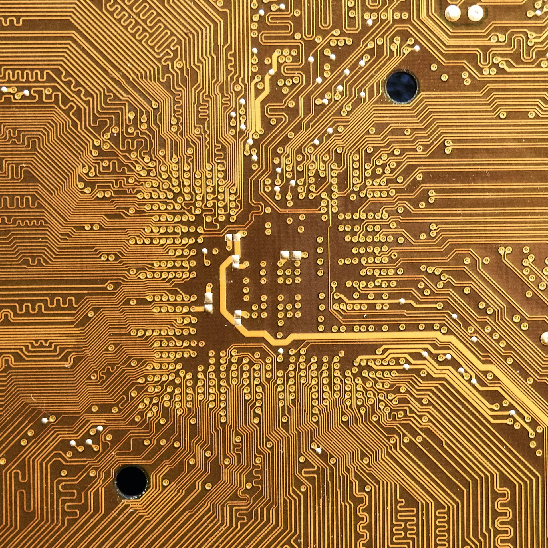 Ein Fragment einer goldfarbenen Computer-Leiterplatte als Nahaufnahme.