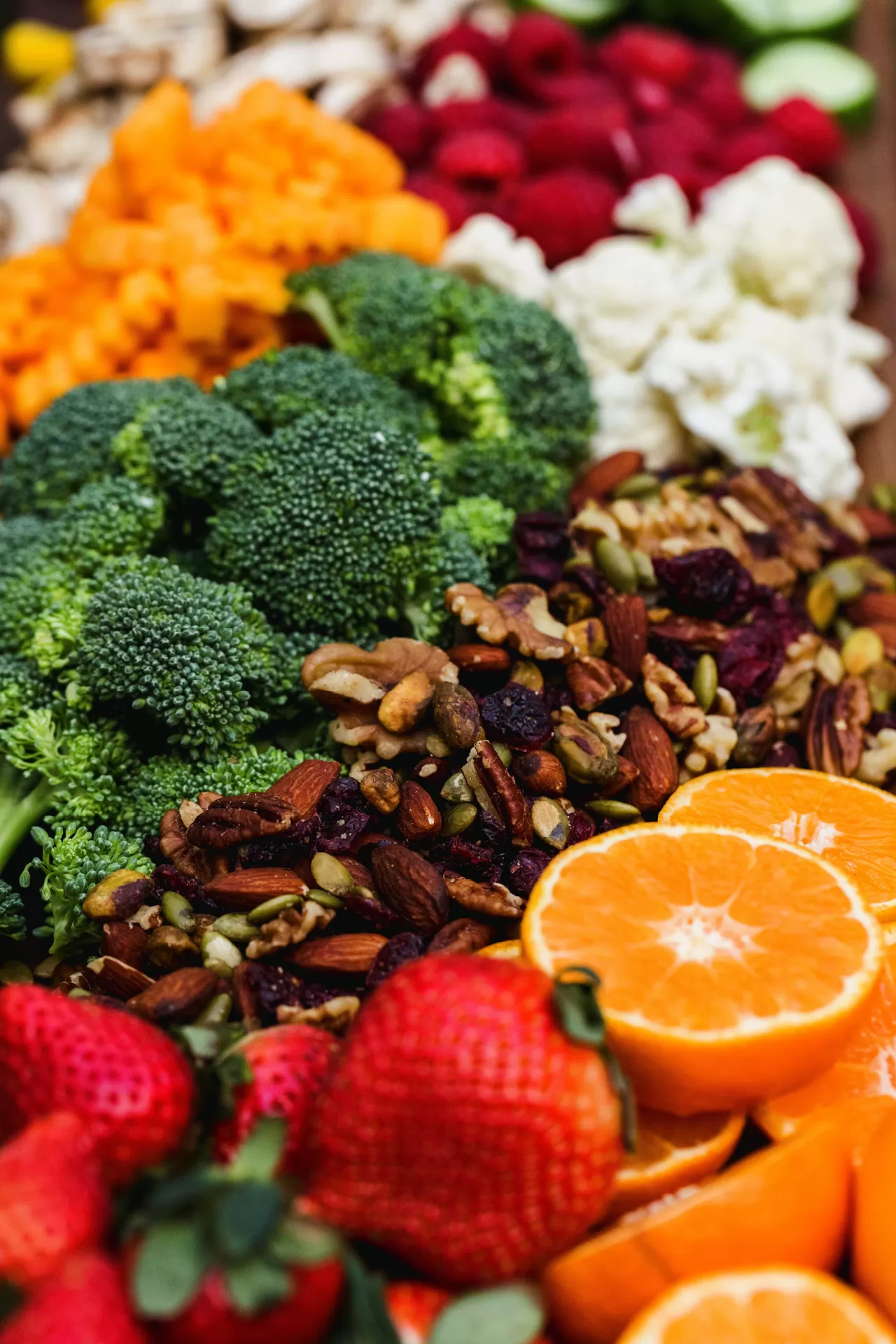 Gesunde Nahrungsmittel schön arrangiert: Gemüse, Broccoli, Nüsse, Erdbeeren und Orangen.