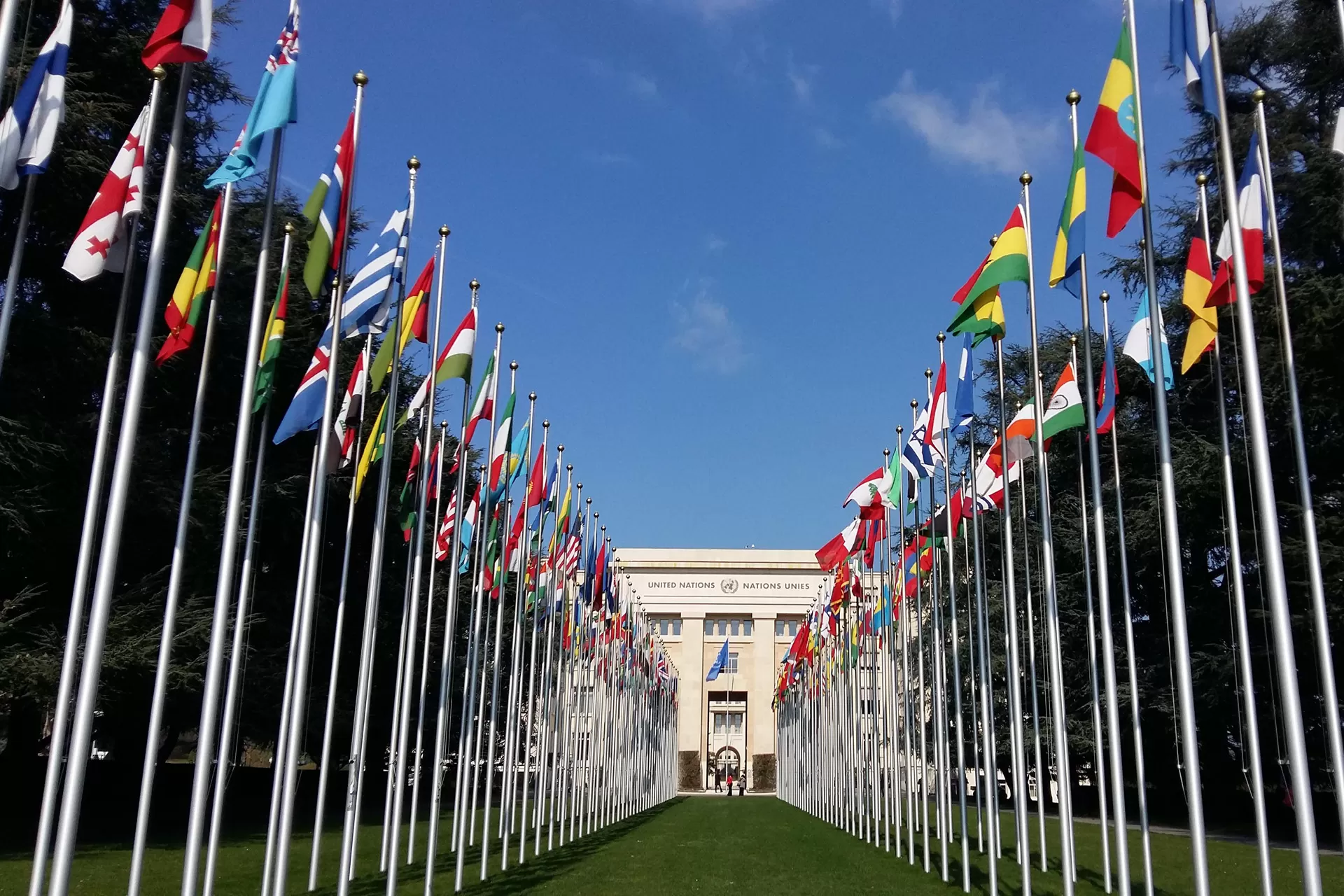 Allee mit Länderflaggen vor dem Gebäude UNO-Gebäudes in Genf.