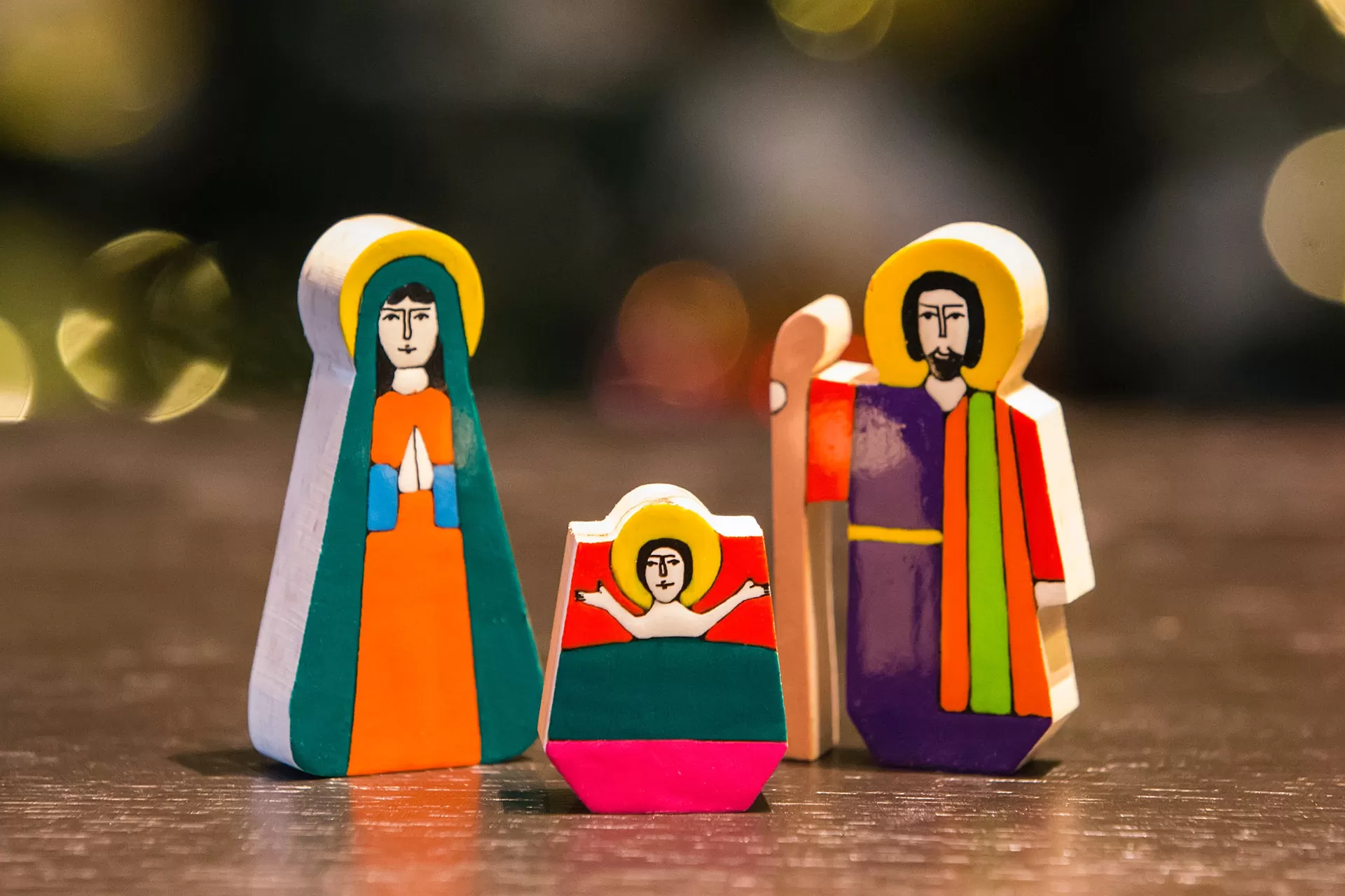 Bunt bemalte Holzfiguren einer Weihnachtskrippe: Maria, Jesuskind und Josef.