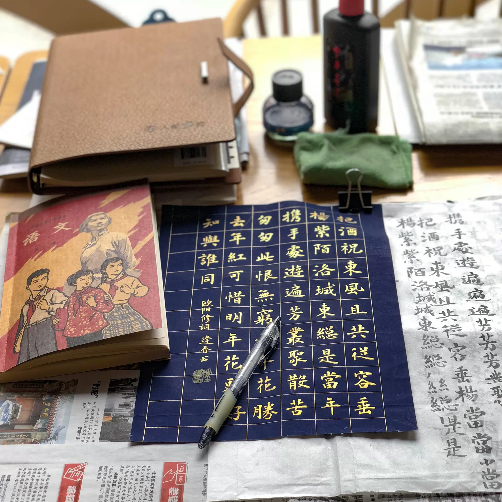 Auf einem Tisch liegen Schriftstücke und Bücher in Chinesischer Sprache sowie Kaligraphie-Utensilien.