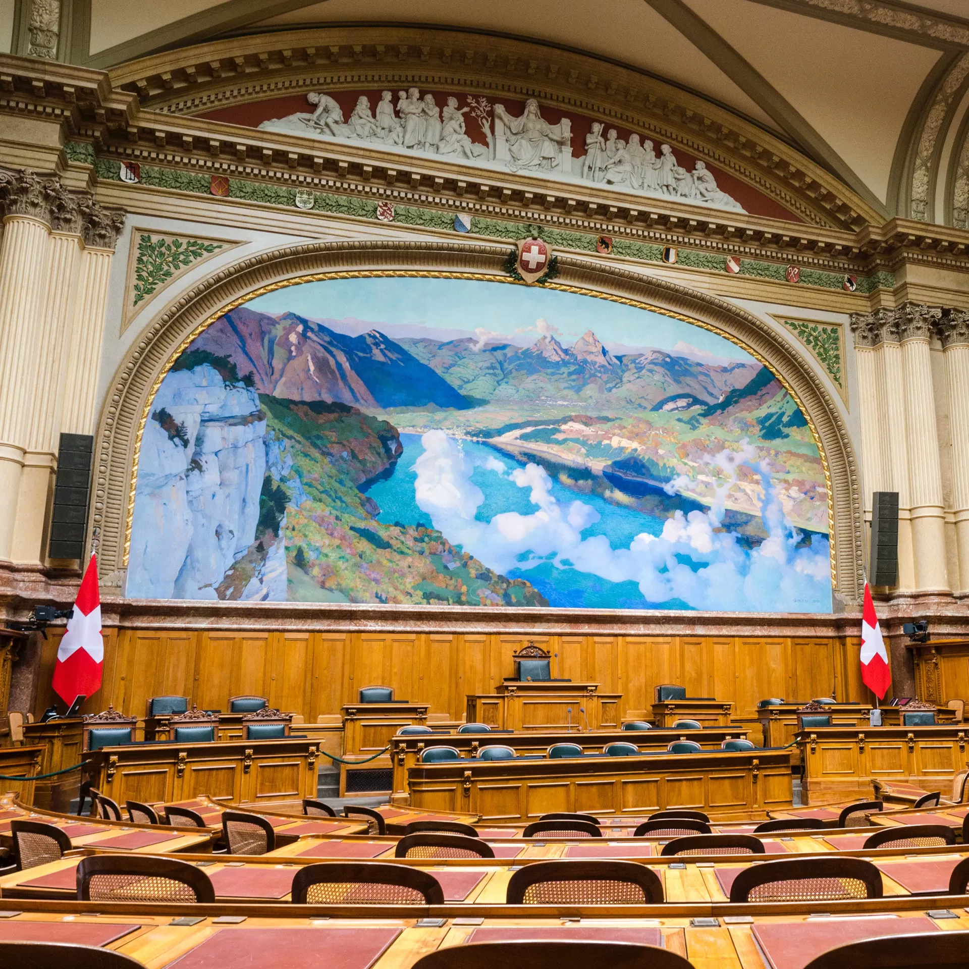 Im Nationalratssaal im Bundeshaus gibt es ein grosses Wandbild der Schweiz, darüber sind die Kantonswappen zu erkennen.