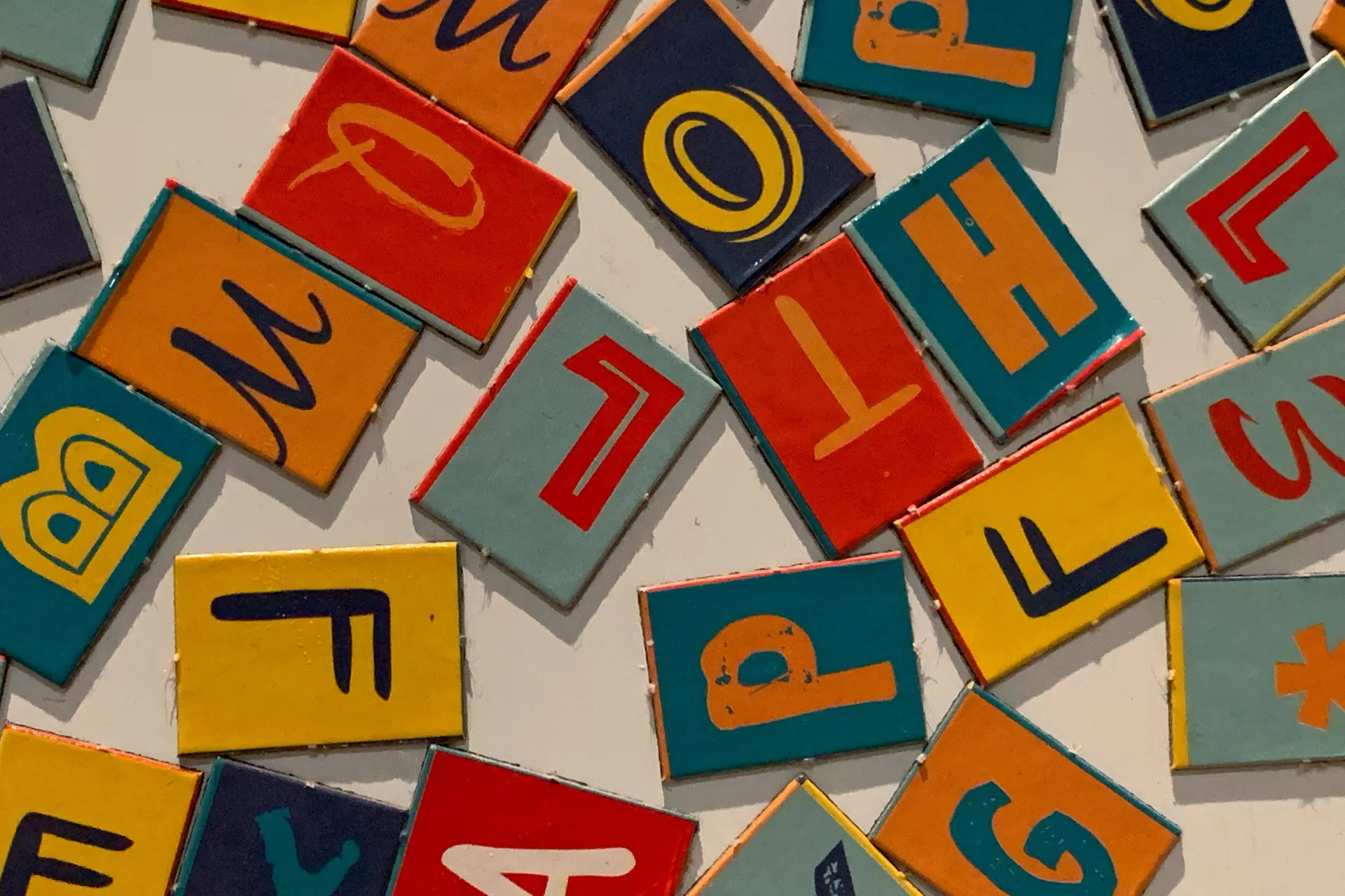 Kartonkärtchen mit unterschiedlichen Buchstaben in verschiedenen Schriften und Farben.