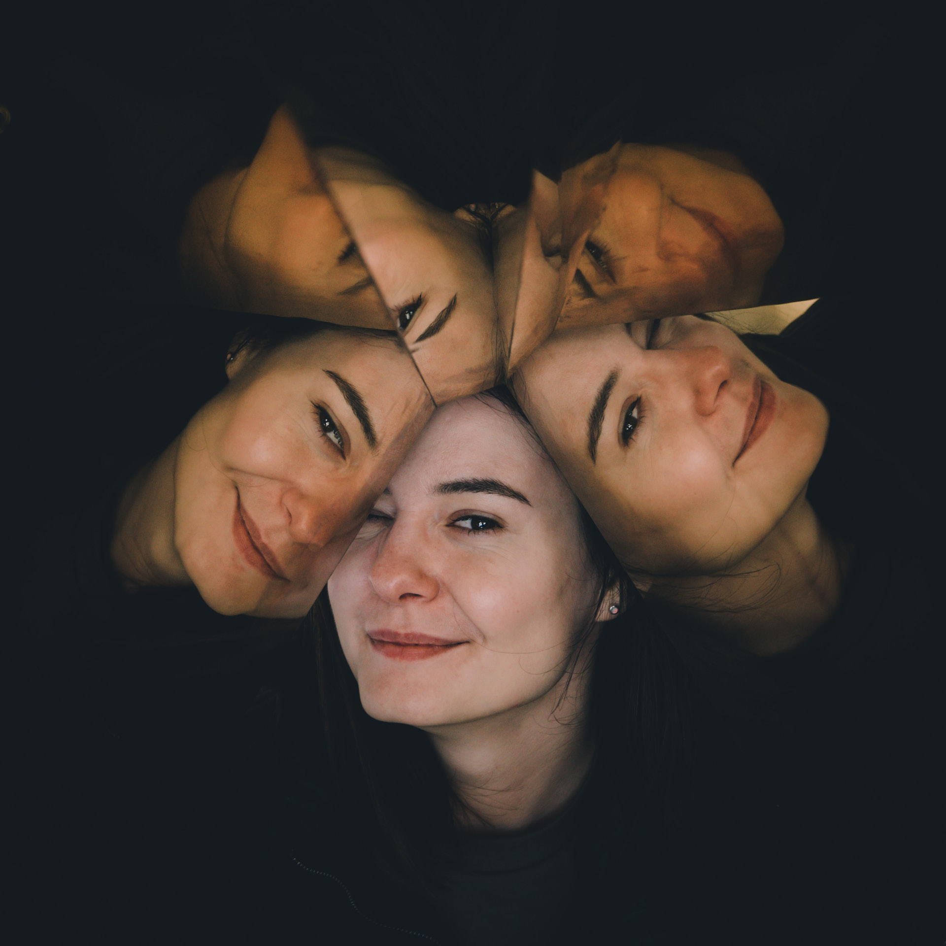 Porträt einer jungen Frau in den gespiegelten Facetten eines Kaleidoskops.